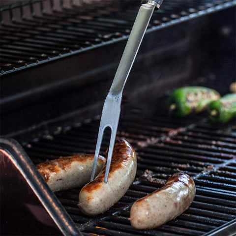 Forchetta barbecue in acciaio con salsicce sulla griglia, perfetta per afferrare e sollevare alimenti senza scottarsi