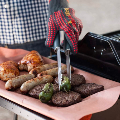 Forchetta barbecue in uso pratico con salsicce, hamburger e peperoni sulla griglia per cottura perfetta