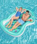 Coppia che si rilassa su lettino gonfiabile doppio Bestway in piscina, con portabevande per il massimo comfort estivo