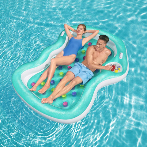 Coppia che si rilassa su lettino gonfiabile doppio Bestway in piscina, con portabevande per il massimo comfort estivo